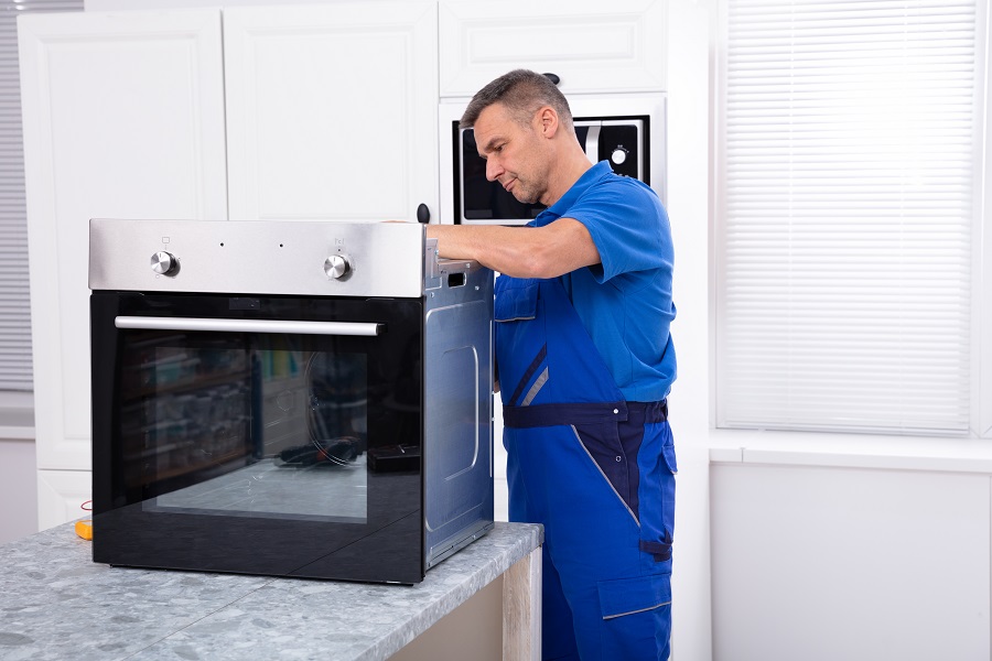 Oven technician repairing oven on kitchen worktop Perth